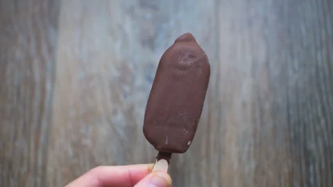 Ice cream double milk chocolate coating, caramel sauce filling on stick bar Stock Footage 336799783