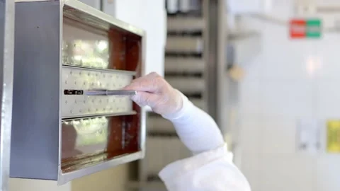 Ice cream factory worker inserting heart shaped strawberry sundaes into a Stock Footage 234957263