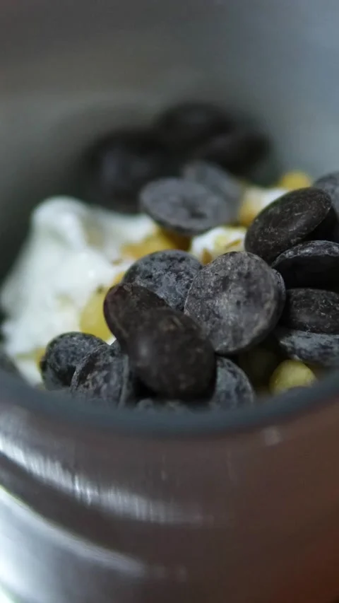 Ice cream maker mixing pine nuts milk liqueur dark chocolate slices and alcohol Stock Footage 318728361