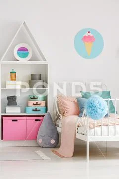 Ice cream poster on white wall above bed in scandi child's bedroom interior Stock Photos