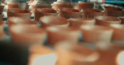 Ice cream production line, adding creamy ice cream to a waffle cup. Stock Footage 254594194