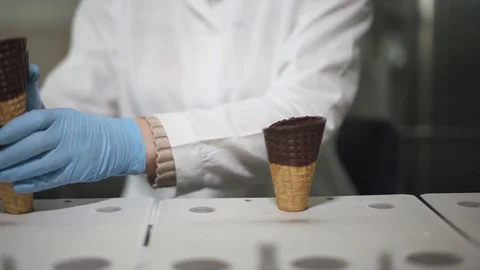 Ice cream production, the worker distributes waffle-cones for ice cream on the Vídeo Stock 107124683