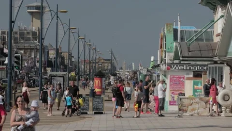 Ice cream queue on busy seafront Video stock 131118188