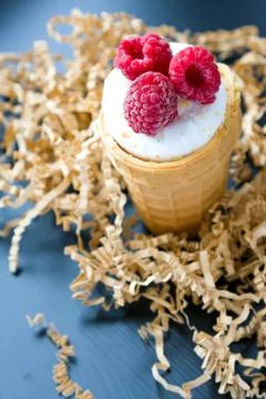 Ice cream with raspberry in waffle cone on wood Stock Photos