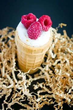 Ice cream with raspberry in waffle cone on wood Stock Photos