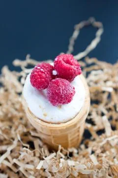 Ice cream with raspberry in waffle cone on wood Stock Photos