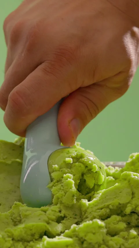 Ice cream scooping. Scoop green ice cream. Vertical close-up Stock Footage 311546502