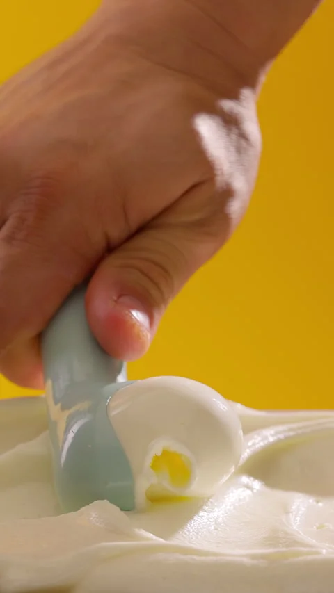 Ice cream scooping. Scoop vanilla gelato on orange background. Summer refreshing Stock-Footage 314135669