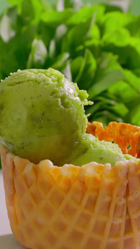 Ice cream scoops stacked into waffle cone. Waffle cup filled with green sorbet Stock Footage 314131163