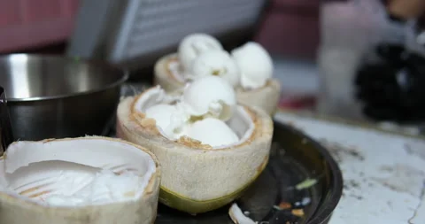 Ice cream served in coconut, put ice cream balls in green coconut shell Stock Footage 277600647
