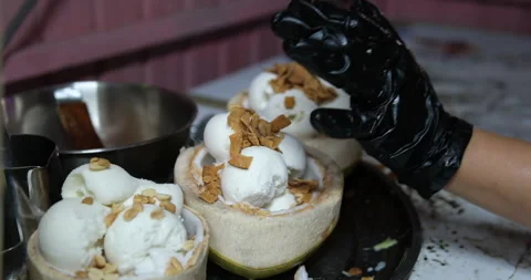 Ice cream served in coconut, sprinkle with nuts, peanuts Stock Footage 277563184