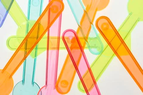 Ice cream spoon in transparent plastic. Different colors and positions. Stock Photos