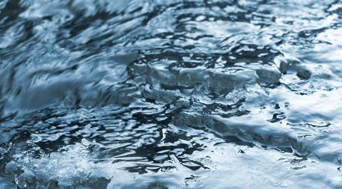 Ice crystal structures are in a flowing stream water, close-up Stock Photos