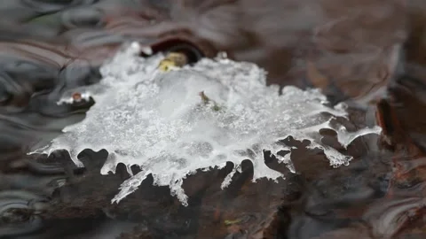 Ice crystals on the surface of flowing water Stock Footage 146206801