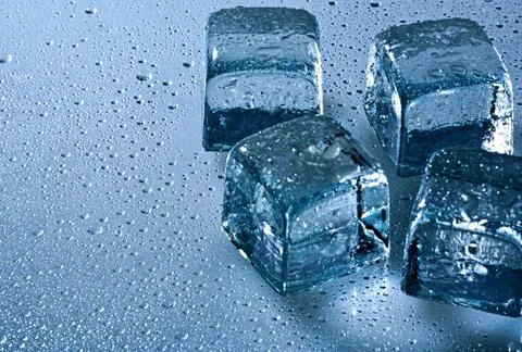 Ice cube and water drops on the wet background Stock Photos