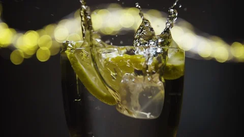 Ice cube dropped into glass full of soda and lemon, lime. Stock Footage 128443774