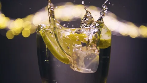 Ice cube dropped into glass full of soda and lemon Stock Footage 128699299