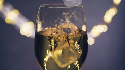 Ice cube dropped into glass full of wine. Stock Footage 128921993