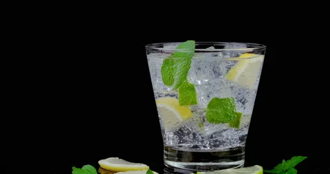 Ice cube dropping to refreshing soda tonic bubble with lemon and mint leave Stock Footage 145731844