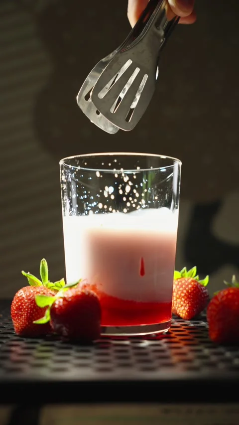 Ice Cube Dropping Into Strawberry Milk Drink in Slow Motion Stock Footage 338233662