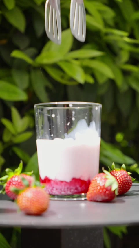 Ice Cube Dropping into Strawberry Milk Drink, Slow Motion Stock Footage 338447884