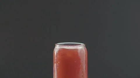 Ice cube drops into cold fruit cocktail Stock Footage 97752188
