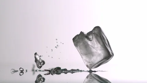 Ice Cube falling and splitting into white background Video stock 104646961