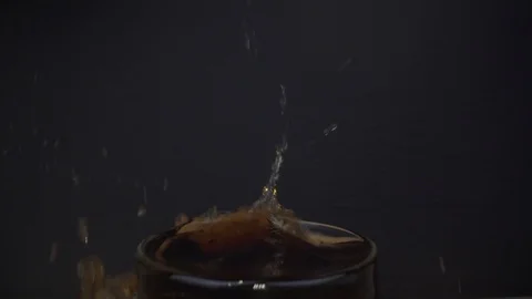 Ice cube falling into coca cola in wide angle macro shot slider Stock Footage 124018446