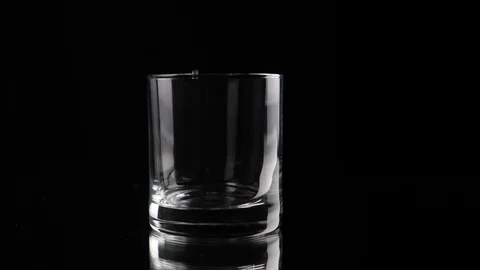 Ice cube falling into empty glass Stock Footage 100956320
