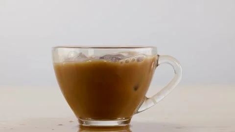 Ice Cube Falling into Glass Cup of Iced Coffee with Splash Stock Footage 341854560