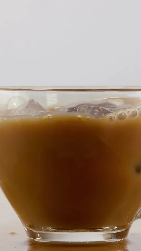 Ice Cube Falling into Glass Cup of Iced Coffee with Splash Stock Footage 343593259