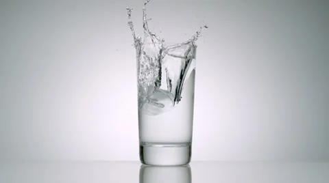 Ice cube falling into glass of water, Slow Motion Video stock 9280097