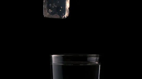 Ice cube falling into glass of water on ... | Stock Video | Pond5