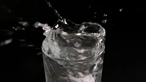 Ice cube falling into a glass of water Stock Footage 74343815