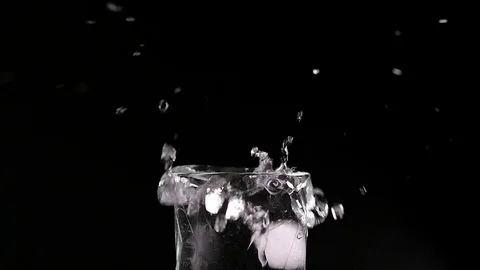 Ice cube falling into a glass of water Stock Footage 74343886