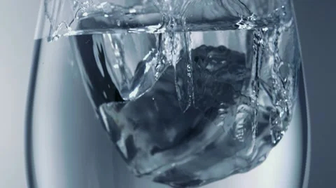 Ice cube falling into glasses of water, Slow Motion Stock Footage 9282474