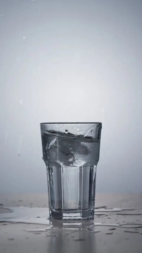 Ice cube falls into the glass and splashes water in slow motion Stock Footage 342727790