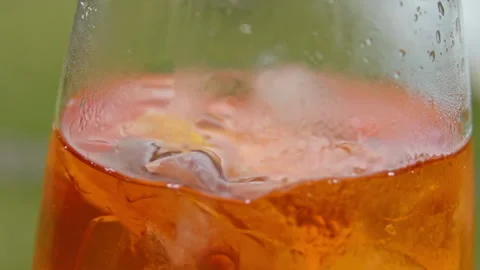 Ice cube falls into glass with aperol spritz cocktail Stock Footage 168769126
