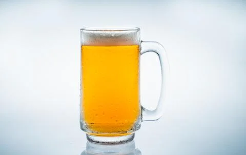 Ice cube fell into the glass of water. Water splashed from the clear glass... Stock Photos