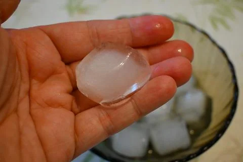 Ice Cube in Hand Close-Up, Heatwave at Home Cooling Concept Fotos Stock