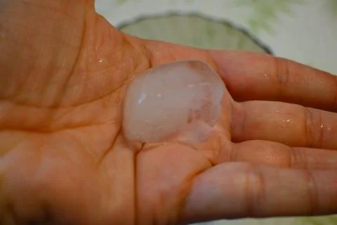 Ice Cube in Hand Close-Up, Heatwave at Home Cooling Concept Stockfoto's