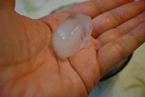 Ice Cube in Hand Close-Up, Heatwave at Home Cooling Concept Stockfoto's