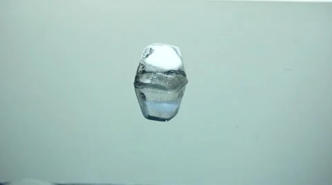 Ice cube melting on reflection surface, close-up. Stock Footage 39972516