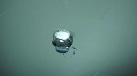Ice cube melting on reflection surface, close-up. 動画素材 39973986