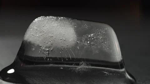 Ice cube melting time lapse on dark background, macro view. Eco-frendly Video stock 144022455