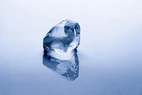 Ice cube melts in studio: Global warming concept Stock Photos