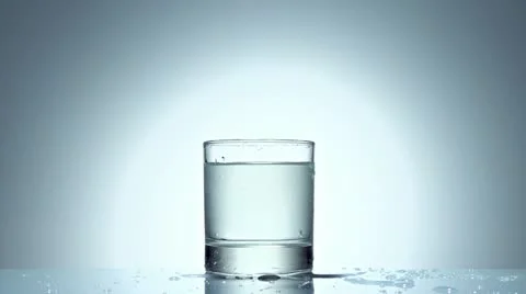 Ice cube splash in glass of water, slow motion Stock Footage 21430772
