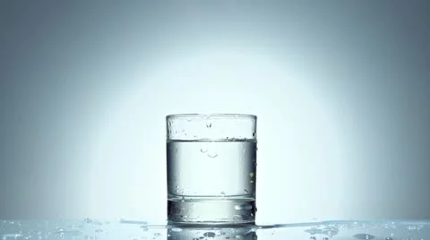 Ice cube splash in glass of water, slow motion Stock Footage 21430856