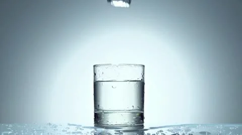 Ice cube splash in glass of water, slow motion Stockbeeldmateriaal 21430872