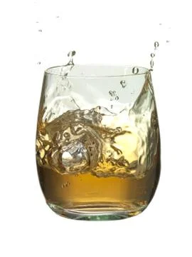 Ice cube splashed into the glass of brandy Stock Photos
